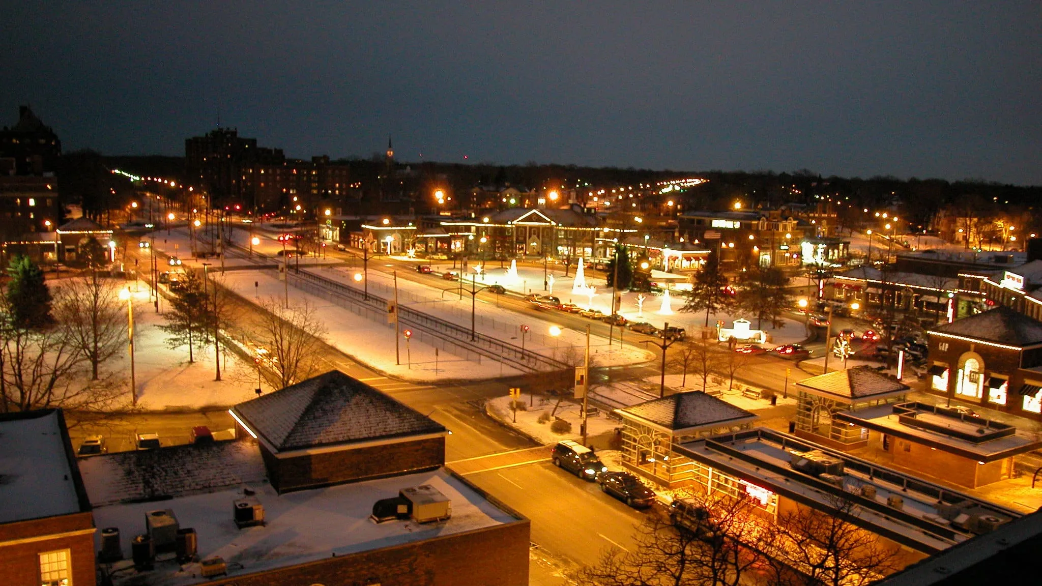 Overhead night view of snowy Shaker Square and surrounding neighborhood, with festive holiday seasonal lights